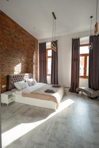 a bedroom with a large bed and a brick wall at Vintage Apartament Turda in Turda +15 photos