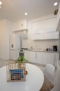 a kitchen with white cabinets and a table with a plant at Vintage Apartament Turda in Turda