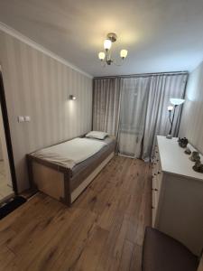 a small bedroom with a bed and a desk at Mały pokój przy lotnisku in Poznań