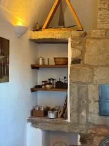 a kitchen with a stone wall with shelves at Dammuso del Nonno in Pantelleria