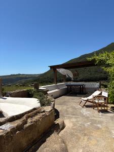 a patio with a table and a picnic table at Dammuso del Nonno in Pantelleria +16 photos