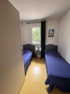 two beds in a small room with a window at Villa de 6 pers, 500m plage. in Soulac-sur-Mer