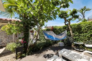 a hammock hanging from a tree in a garden at Beachfront House with Private Heated Jacuzzi and Garden Zadar in Zadar