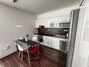 Una cocina con mesa y sillas y un refrigerador. en Bright and Cozy Apartment in Vienna Gate, en Bratislava