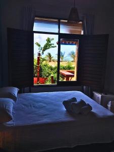 a bedroom with a large bed and a window at Casa d Amar in Paripueira