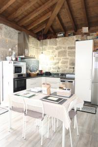 a kitchen with a table with chairs and a refrigerator at Casa Escuela Trasmiras in Trasmiras