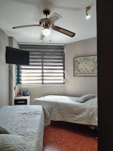 a bedroom with two beds and a ceiling fan at Habitación doble con baño privado, Desayuno y piscina in Alboraya