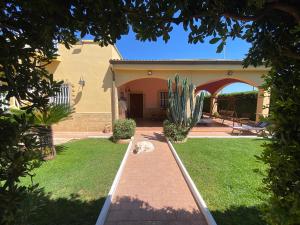 un gatto sdraiato sull'erba di fronte a una casa di Villa Gilda a Gallipoli