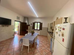 una cucina con un tavolo e un frigorifero bianco di Villa Gilda a Gallipoli