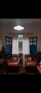 a living room with two beds and a window at Canto Mineiro in Tiradentes