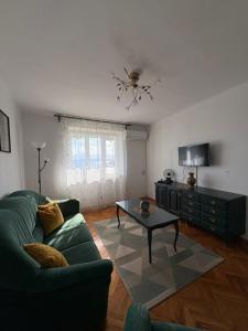 a living room with a green couch and a table at Holiday house Belavista in Novi Vinodolski