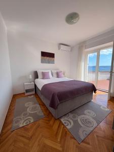 a bedroom with a large bed and a large window at Holiday house Belavista in Novi Vinodolski