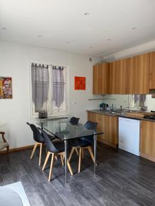 a kitchen with a glass table and some chairs at Maison Antibes in Antibes