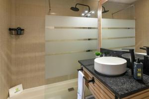 a bathroom with a sink and a mirror and a tub at Priolo's Nest - Azores Butler in Bicas +12 photos