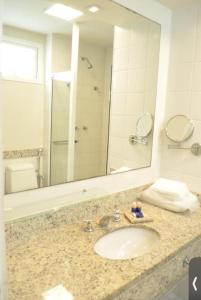 a bathroom with a sink and a large mirror at Búzios Beach Resort in Búzios