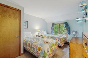 a bedroom with two beds and a window at Wooded Oasis in Edgartown +13 photos