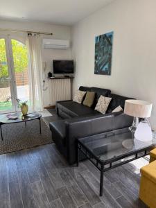 a living room with a black leather couch and a table at Maison Antibes in Antibes