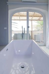 イスキアにあるEremo di Montevergine Ischia Apartmentsの窓付きの客室で、白いバスタブが備わります。
