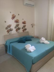 a bedroom with a blue bed with towels on it at A Casuzza in Salemi