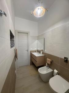 a bathroom with a white toilet and a sink at A Casuzza in Salemi +22 photos