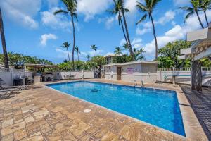 a swimming pool with palm trees in the background at KAC201 Across from the Beach - Cozy Studio with Ocean View in Wailea