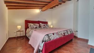 a bedroom with a large bed with a red headboard at Ma Maison 3 in Livorno