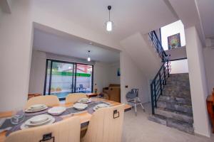 a dining room with a table and chairs and a staircase at Villa Özel in Fethiye