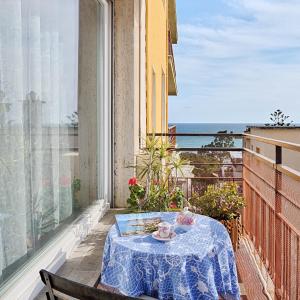 un tavolo su un balcone con vista sull'oceano di MonnaLisa ad Arma di Taggia