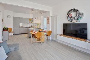 un soggiorno con tavolo da pranzo e grande TV di MonnaLisa ad Arma di Taggia