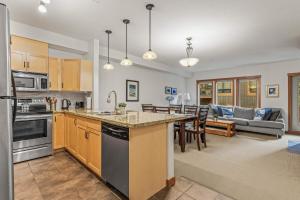 cocina abierta y sala de estar con sofá en Evergreen Escape - 2 Bedroom Condo with Pool & Hot Tub, en Canmore