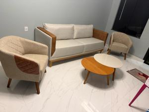 a living room with a couch and two chairs and a table at Porto Marina Residence in Ananindeua
