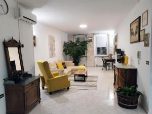 a living room with yellow chairs and a couch at Appartameno Calnova in Vodnjan