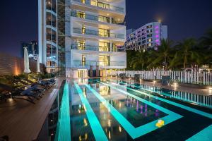 - une piscine en face d'un bâtiment la nuit dans l'établissement Mera Mare Pattaya, à Pattaya