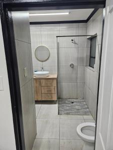 Un baño con ducha, lavabo e inodoro. en 43 Home apartment, en Del Judor