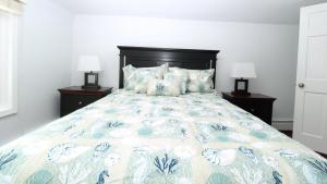 a bedroom with a bed with a blue and white comforter at Second Floor Condo - Pool - 4 Bedrooms in West Cape May +26 photos