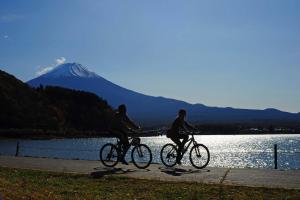 two people riding bikes on a sidewalk near a mountain at Yoshimura Tenjoan in Fujikawaguchiko