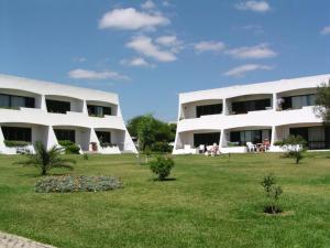 a large white building with people sitting in the grass at Serenity Villa in Porches