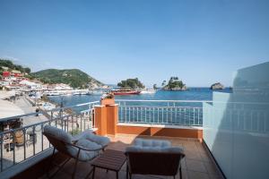 a balcony with chairs and a view of the water at Parga Harbor Suites in Parga