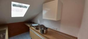 eine kleine Küche mit Spüle und Fenster in der Unterkunft Kleefeld - Ferien- und Messewohnung in Hannover