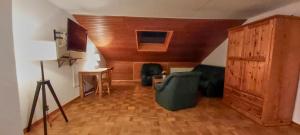 ein Wohnzimmer mit Stühlen und einer Holzdecke in der Unterkunft Kleefeld - Ferien- und Messewohnung in Hannover