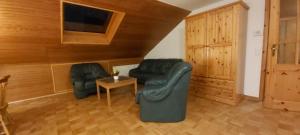 ein Wohnzimmer mit 2 Ledersesseln und einem Tisch in der Unterkunft Kleefeld - Ferien- und Messewohnung in Hannover