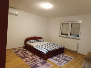 a small bedroom with a bed and a window at Villa Majida Ilidža in Sarajevo