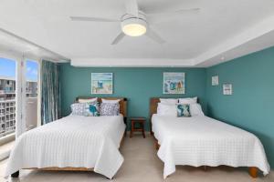 サンファンにあるBeachfront Retreat-Panoramic Sunrise Views-1 Parking Spotの青い壁の部屋にベッドが2つある +27枚の写真