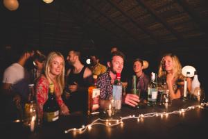 a group of people standing around a bar with bottles of wine at The Bay Agonda in Agonda