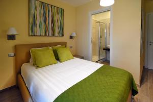 a bedroom with a large white bed with green pillows at CdR Guest House in Rome