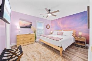a bedroom with a bed with a painting on the wall at Sunset Shack in Myrtle Beach +70 photos