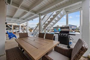 a wooden table and chairs on a patio with a stove at Sunset Shack in Myrtle Beach