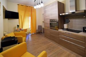 a kitchen with yellow chairs and a living room at CdR Guest House in Rome