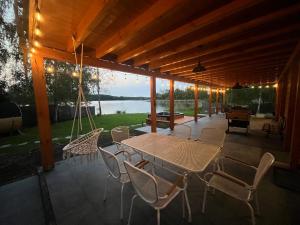 a patio with a table and chairs and a lake at Mazury Lake View in Rusek Wielki
