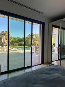 a bedroom with large windows and a tennis court at Villa contemporaine de luxe in Aix-en-Provence